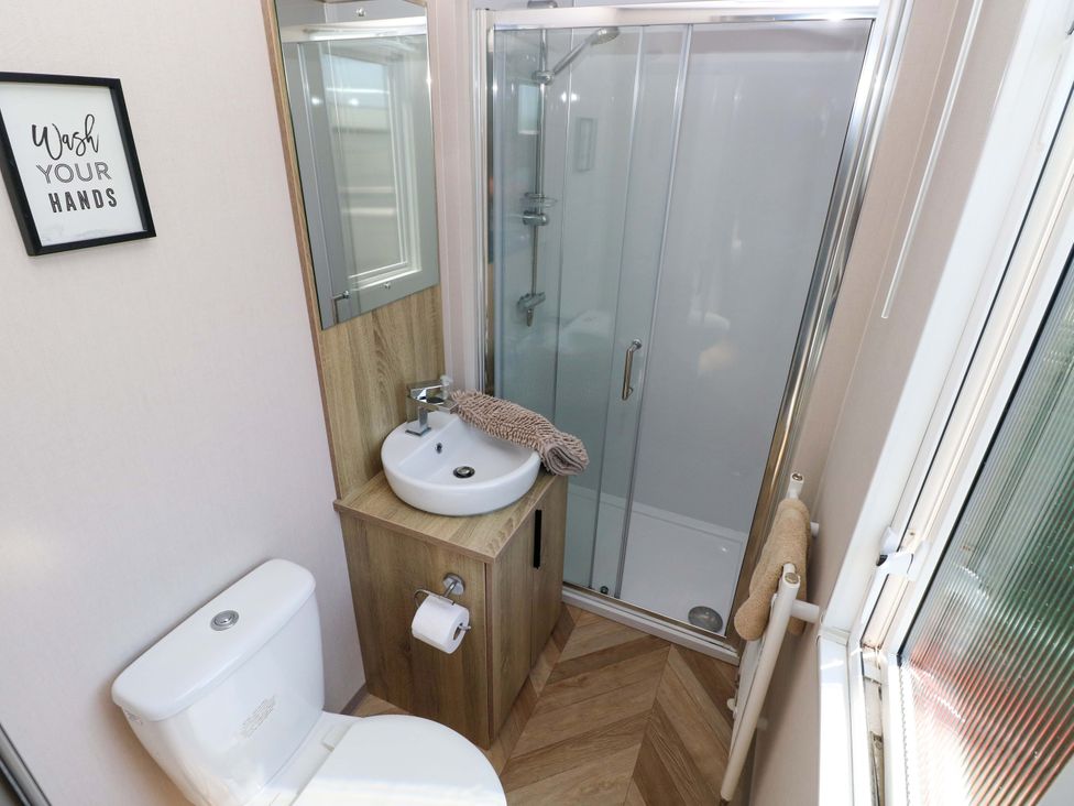 A bathroom with a shower, toilet, and wash basin at No 13 Broadfield Farm Holiday Park in Saundersfoot