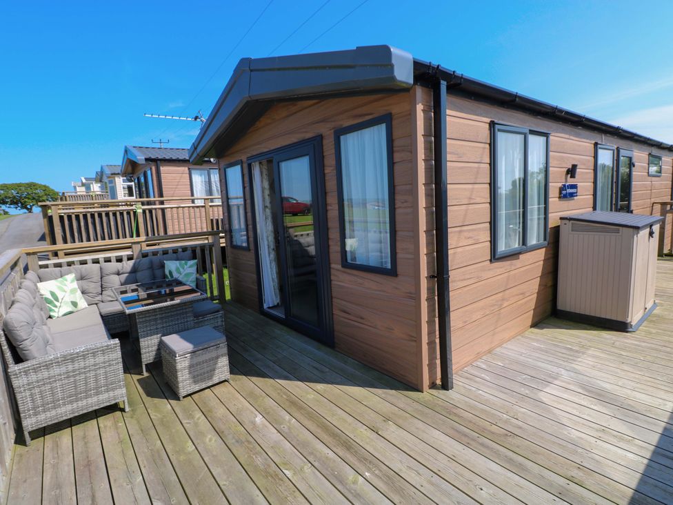 An outdoor patio area with seating and a table at No 13 Broadfield Farm Holiday Park in Saundersfoot