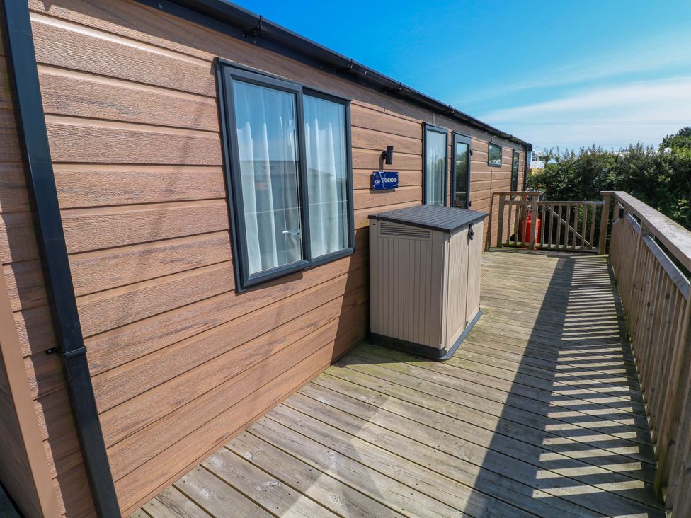 A deck with a storage unit and windows at No 13 Broadfield Farm Holiday Park Saundersfoot