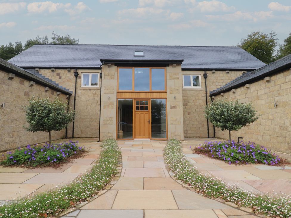 An entrance with a pathway and flowers at Alston House