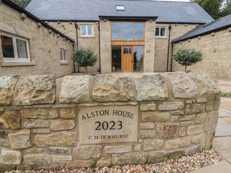 A stone wall with the name Alston House and a front entrance of a house at Alston House