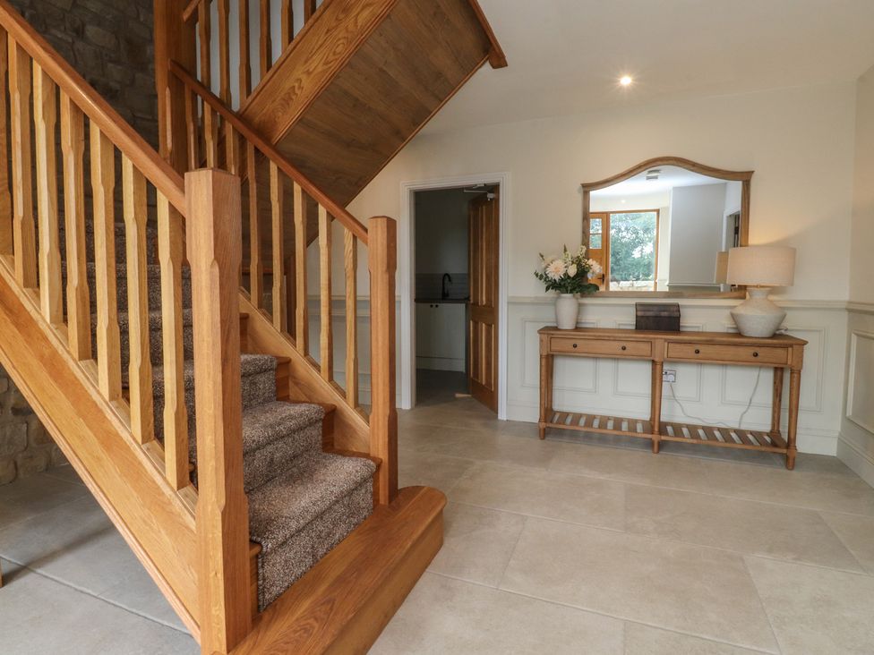 A hallway with stairs and a console table at Alston House