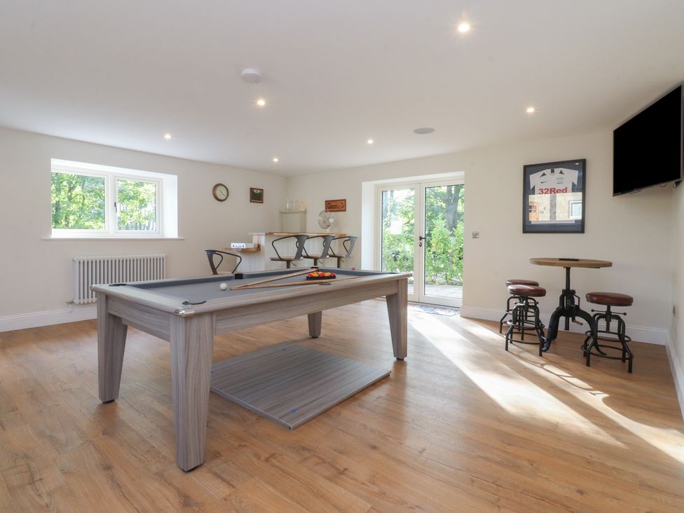 A snug with a pool table and bar stools at Alston House