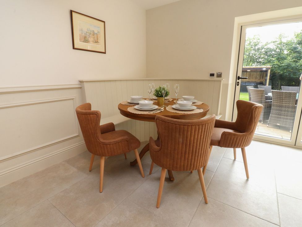 A dining room with a round table and chairs at Alston House 