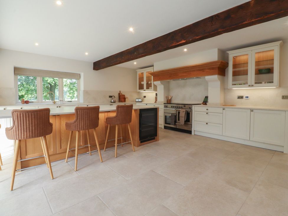 A kitchen with a wooden island and bar stools at Alston House