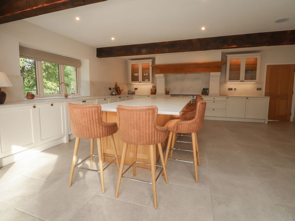 A kitchen with a central island and bar stools at Alston House