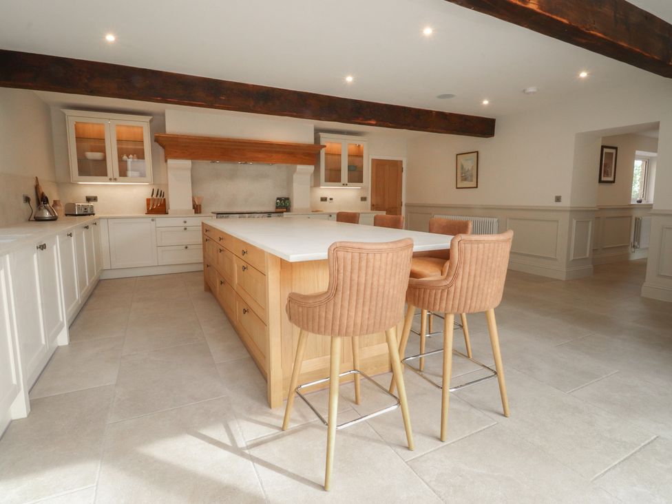 A kitchen with an island and bar stools at Alston House