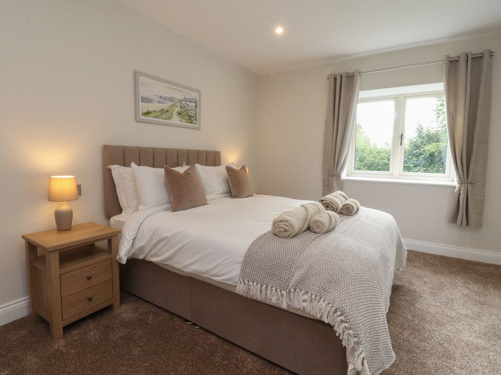 A bedroom with a bed and a bedside table at Alston House