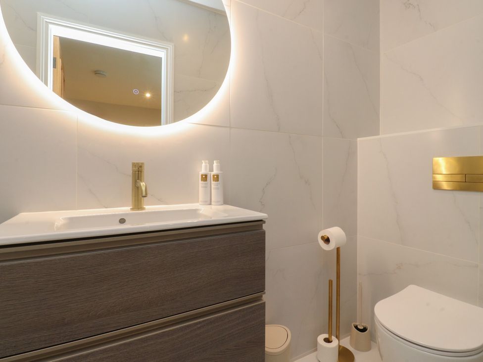 A bathroom with a sink, mirror, and toilet at Alston House 