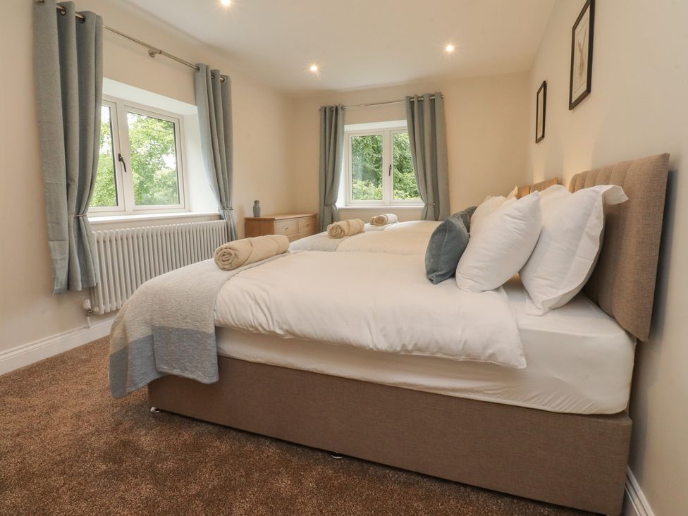 A bedroom with a double bed and two windows at Alston House