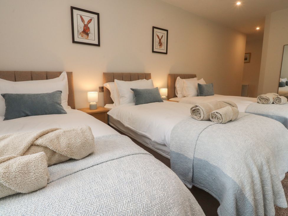 A bedroom with three beds and bedside lamps at Alston House