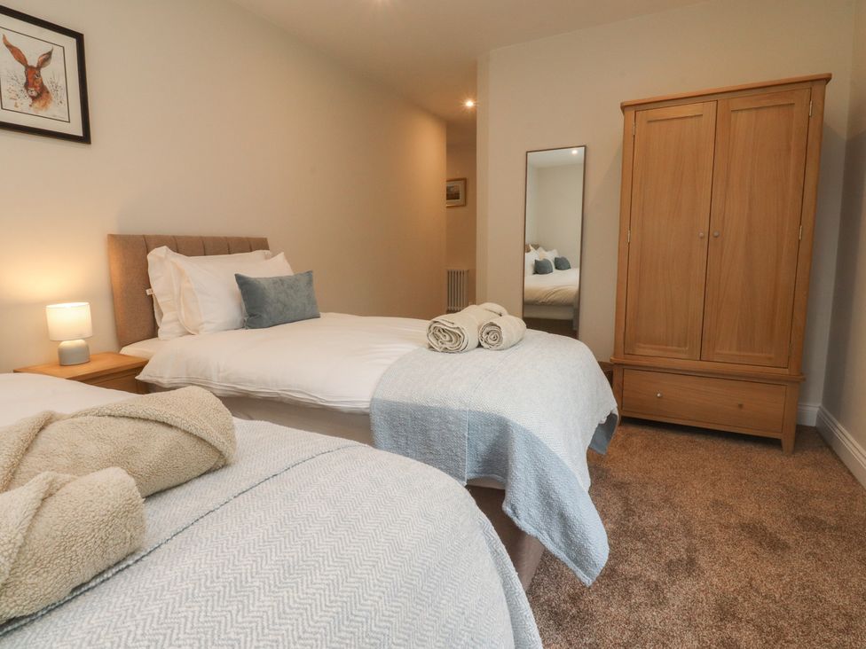 A bedroom with two beds and a wardrobe at Alston House 