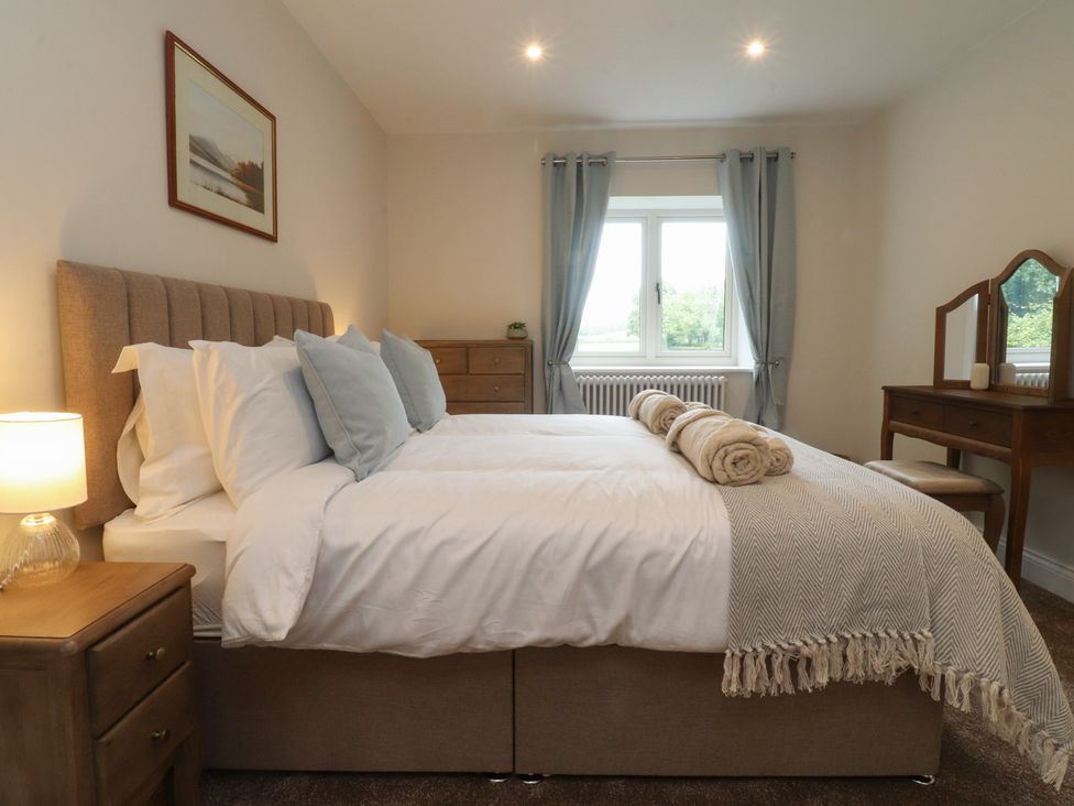 A bedroom with a bed and a dressing table at Alston House
