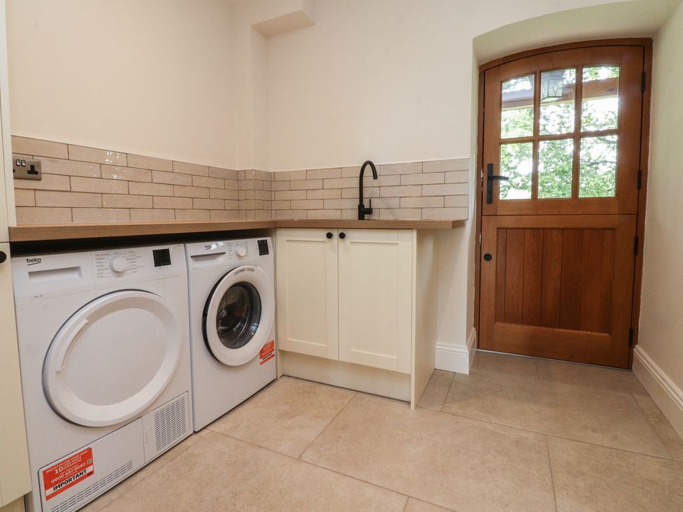 A laundry room with washing machine and tumble dryer at Alston House