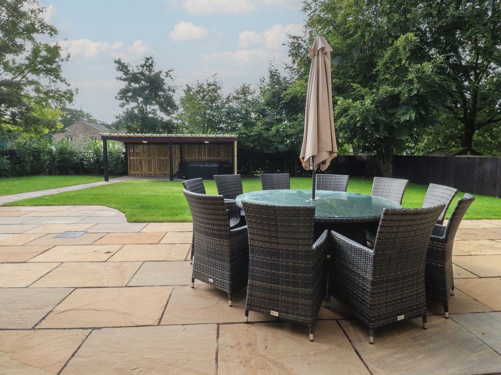 A garden with a table and chairs under a parasol at Alston House 
