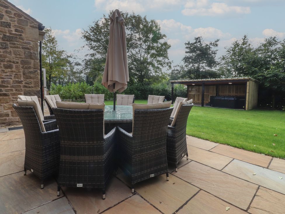 A garden with a table and chairs under an umbrella at Alston House