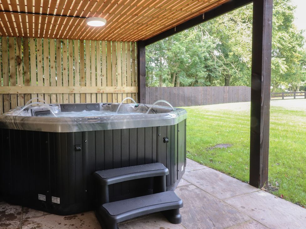 A hot tub on a wooden deck in an outdoor area at Alston House