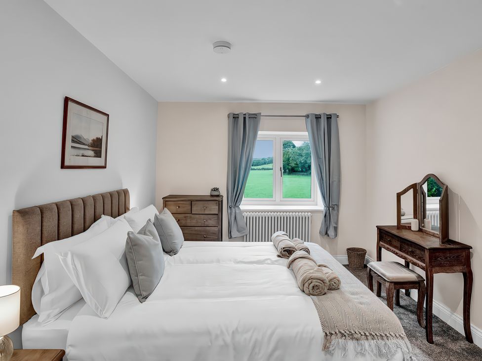 A bedroom with two beds and a dressing table at Alston House in Longridge