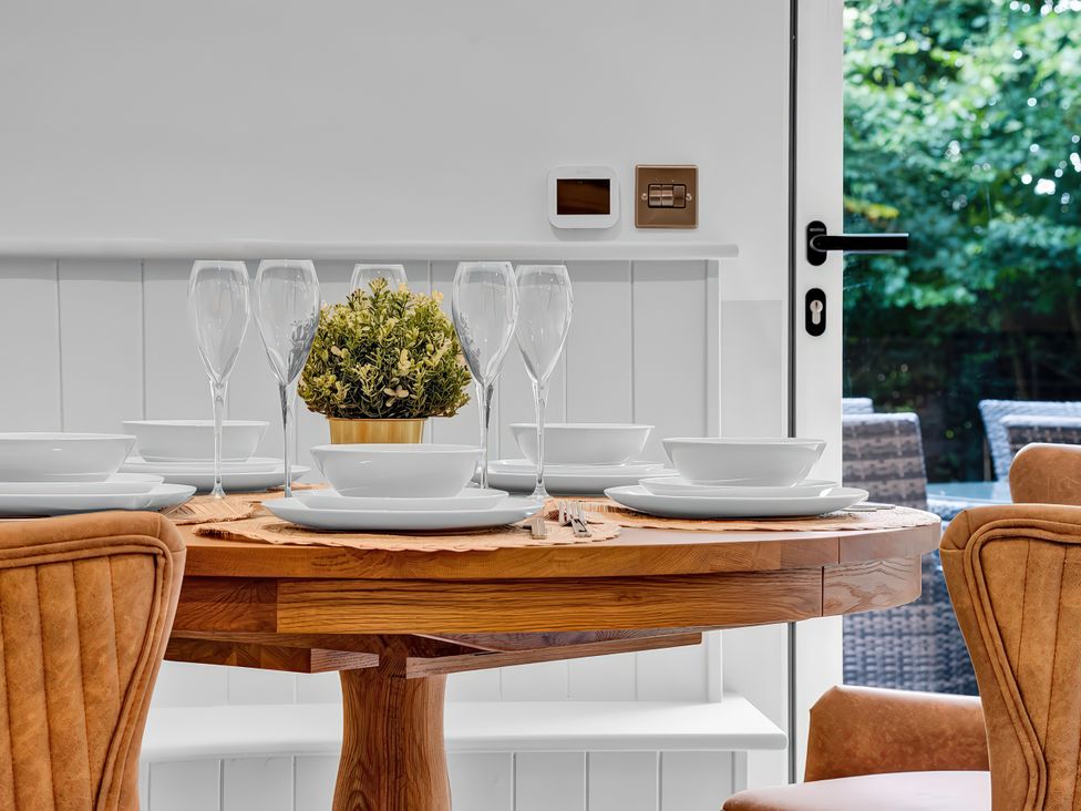 A dining room with a wooden table set for dinner at Alston House in Longridge