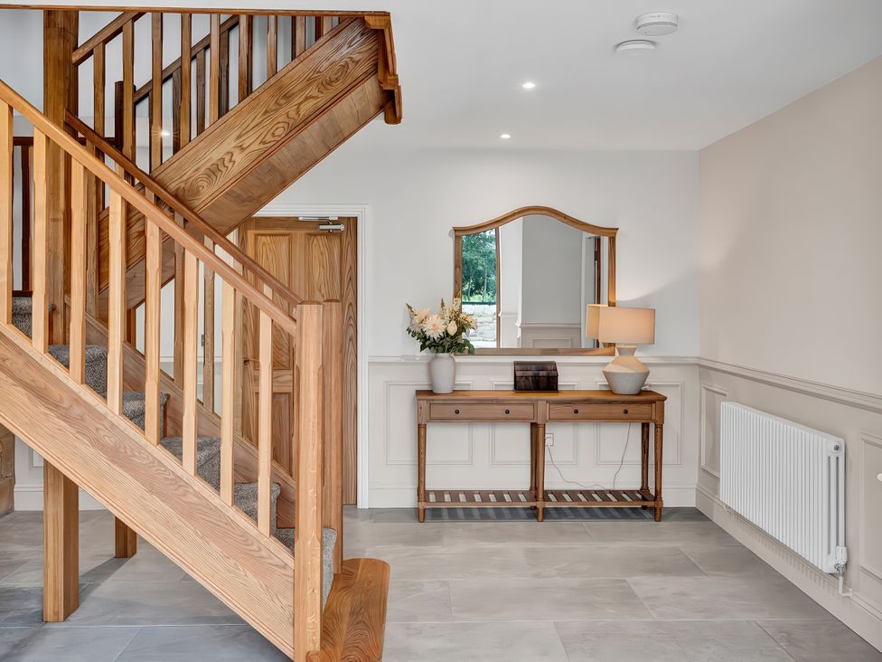 A hallway with a staircase and console table at Alston House in Longridge