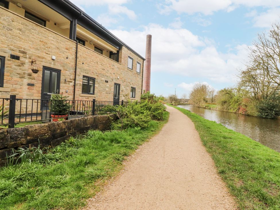 A stone building beside a canal with a pathway at Number 7 Canalside Skipton
