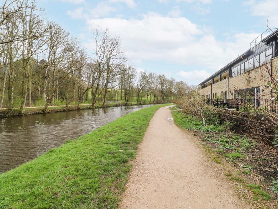 A canal with a path alongside and trees near the building at Number 7 Canalside, Skipton