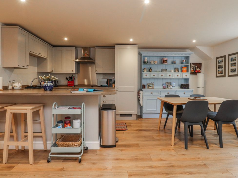 A kitchen with cabinets, sink, dining table and chairs at Number 7 Canalside, Skipton