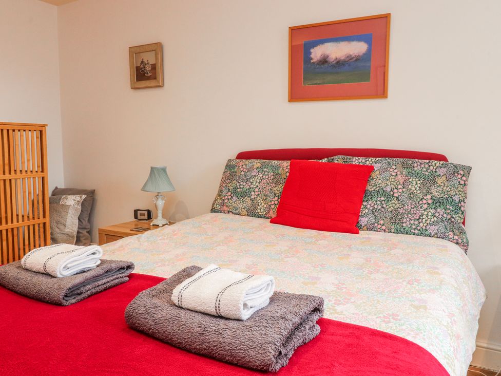 A bedroom with a bed, bedside table, lamp and towels at Number 7 Canalside in Skipton