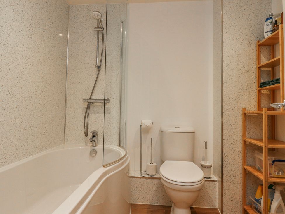 A bathroom with a bathtub, toilet, and shower at Number 7 Canalside, Skipton