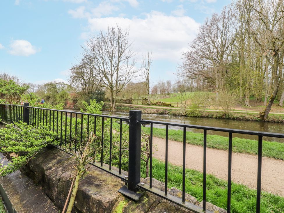 A view of a river with trees and a fence at Number 7 Canalside in Skipton