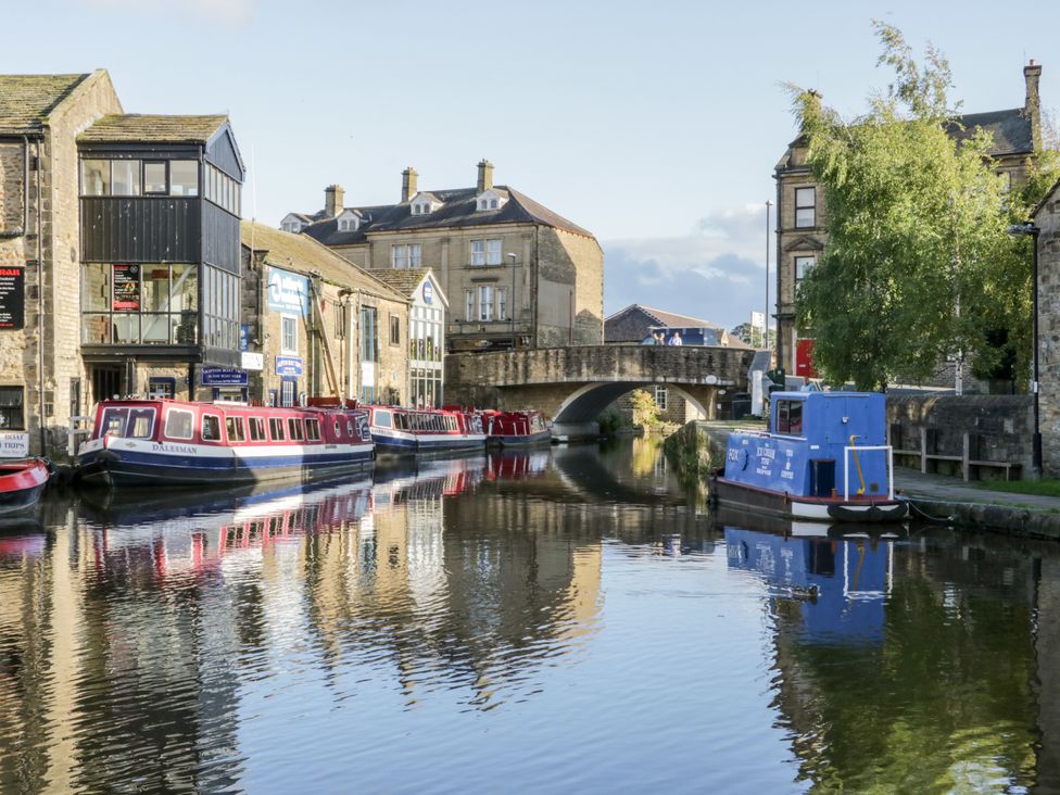 A canal with boats and buildings at Number 7 Canalside in Skipton