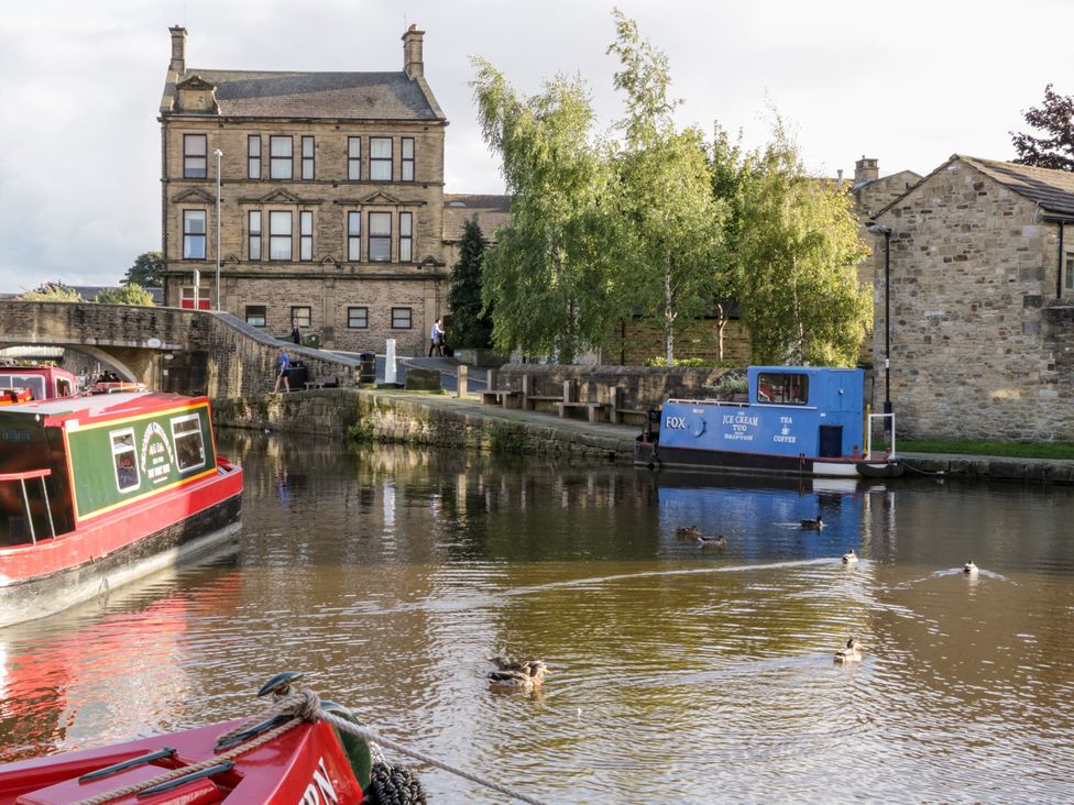 A canal with narrowboats and ducks at Number 7 Canalside in Skipton