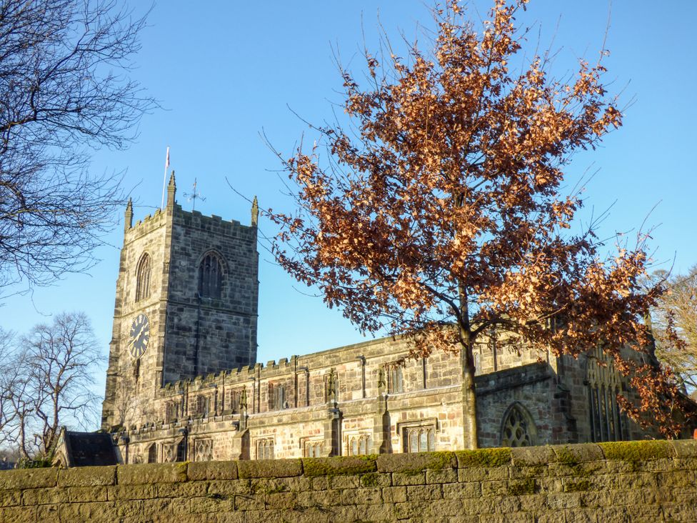 A church building with a clock tower and a tree in front at Number 7 Canalside in Skipton