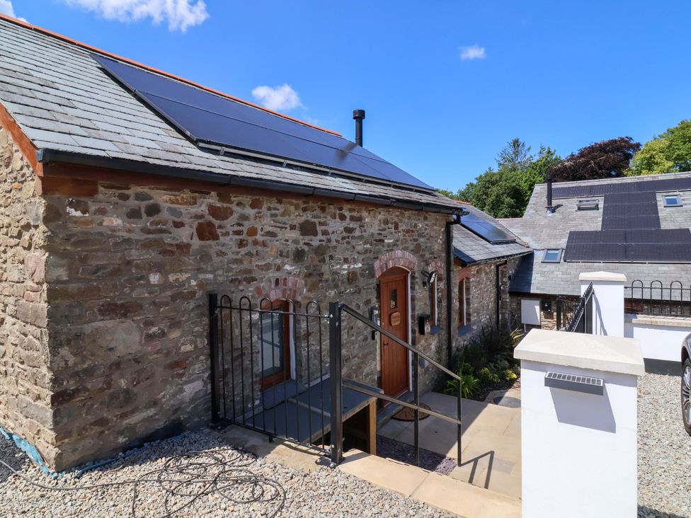 An outdoor view of a cottage with solar panels at Hedgehog Highway in Parkham