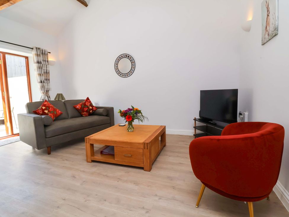 A living room with a sofa, coffee table and television at Hedgehog Highway, Parkham