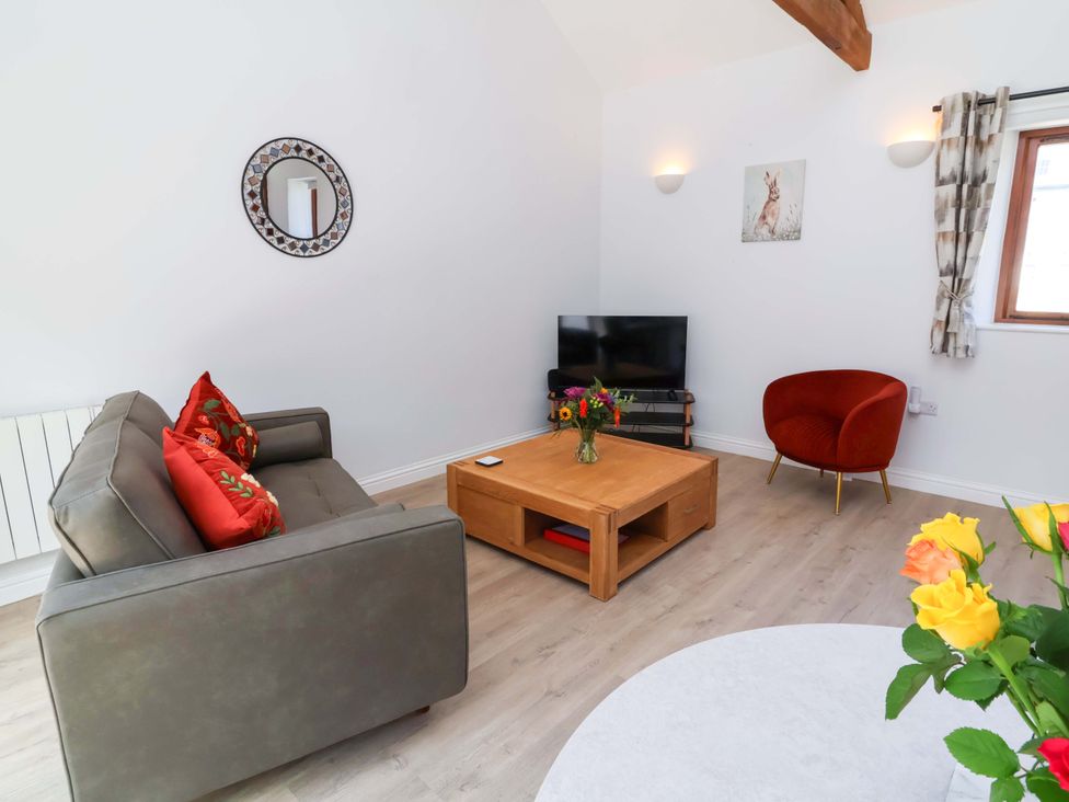 A living room with a sofa and coffee table at Hedgehog Highway in Parkham