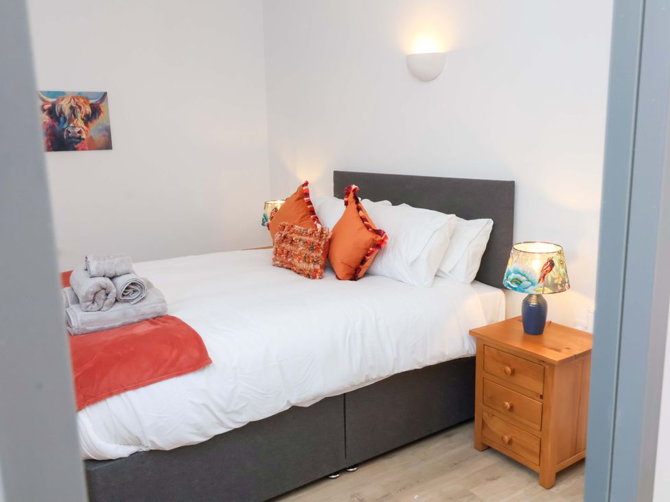 A bedroom with a bed and bedside table at Hedgehog Highway in Parkham