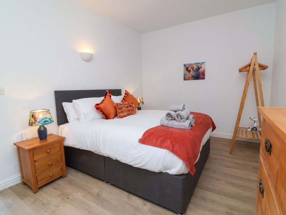 A bedroom with a bed and bedside lamp at Hedgehog Highway in Parkham