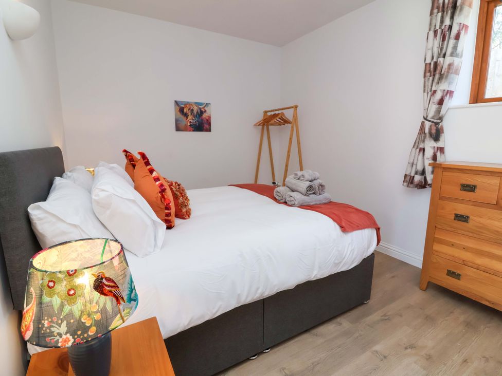 A bedroom with a bed and lamp at Hedgehog Highway Parkham