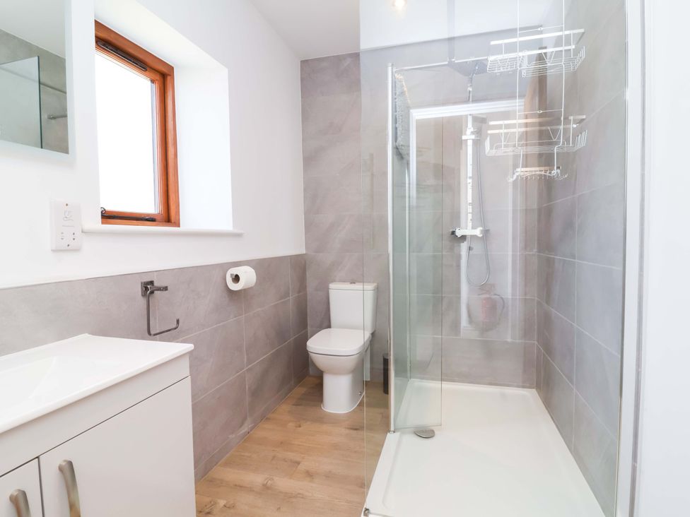 A bathroom with a shower, toilet, and sink at Hedgehog Highway in Parkham