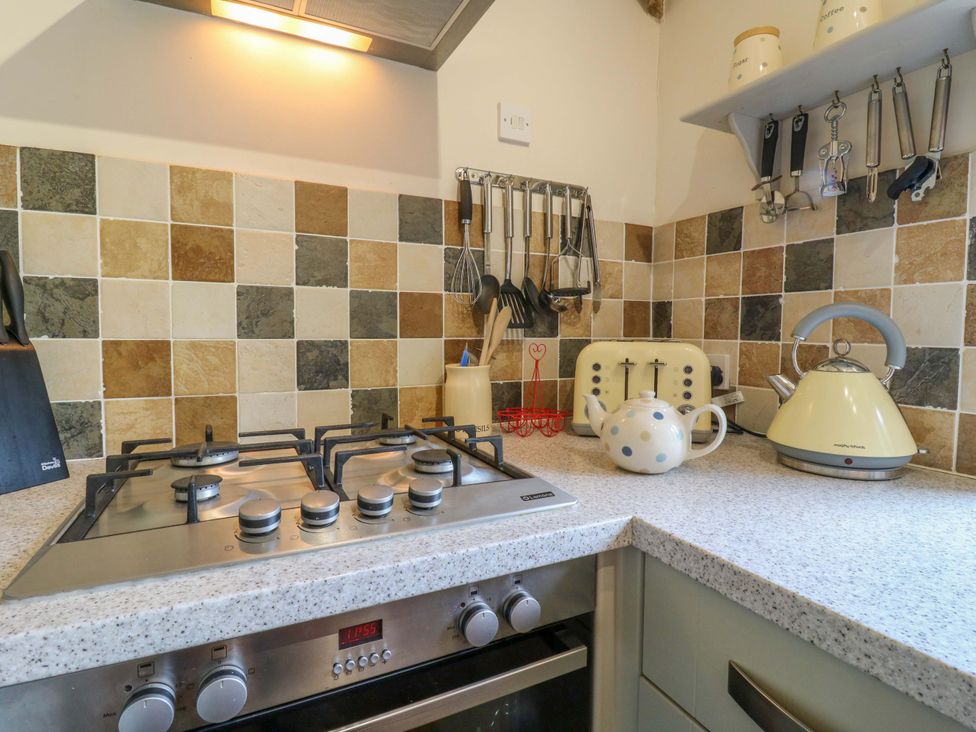 A kitchen with a stovetop, kettle and toaster at The Kiln in Mendham near Harleston