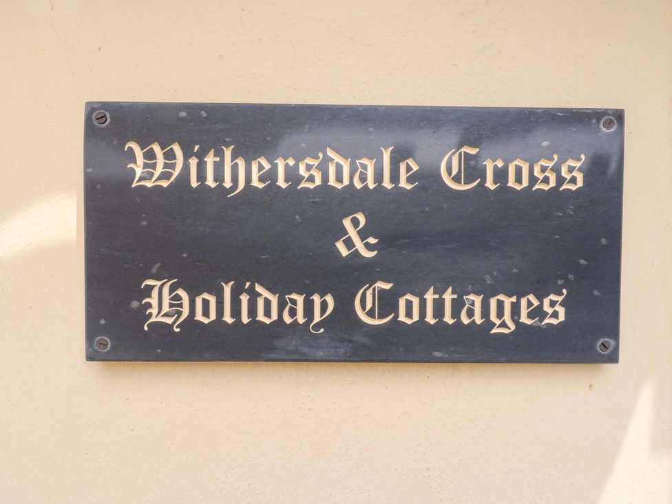 A sign for Withersdale Cross and Holiday Cottages