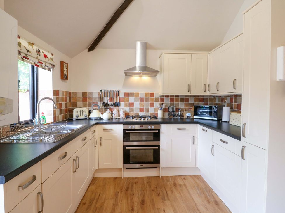 A kitchen with cabinets and appliances at The Golden Cross in Mendham near Harleston