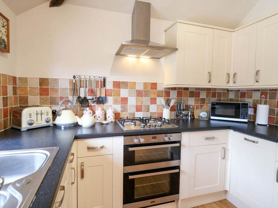 A kitchen with an oven and microwave at The Golden Cross in Mendham near Harleston