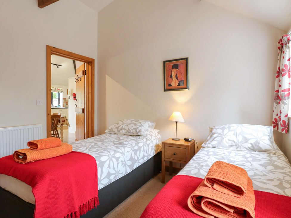 A bedroom with two beds and a bedside table at The Golden Cross in Mendham near Harleston
