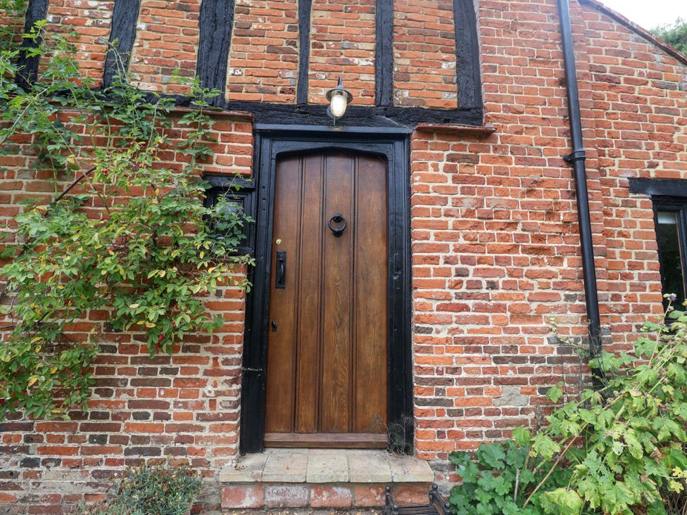 An entrance with a wooden door and plants at Keirs Cottage in Carlton Colville