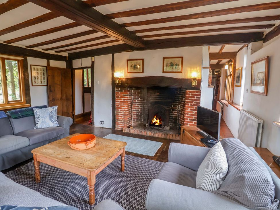 A living room with a fireplace and sofa at Keirs Cottage in Carlton Colville