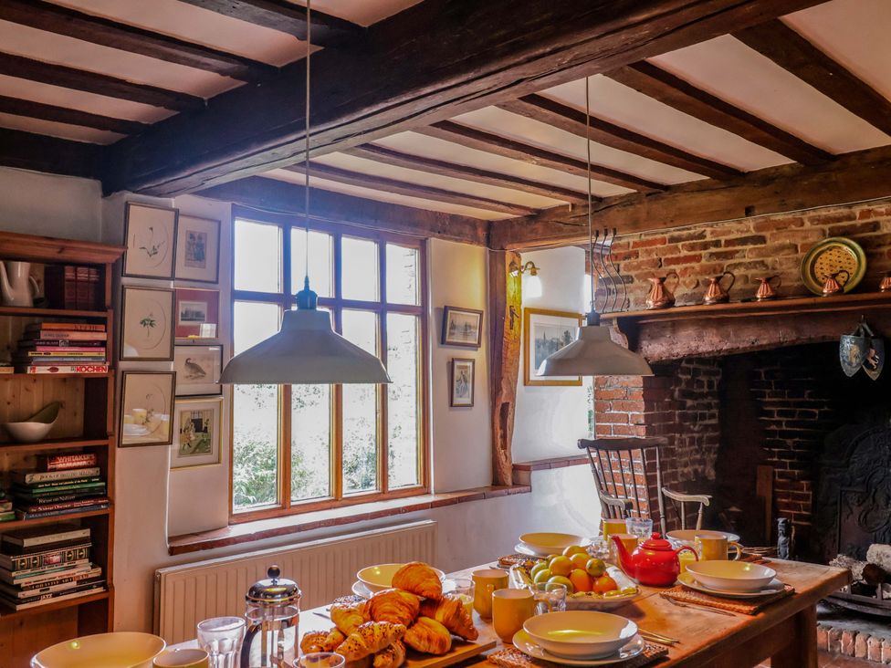 A kitchen with a dining table set with food and window at Keirs Cottage in Carlton Colville