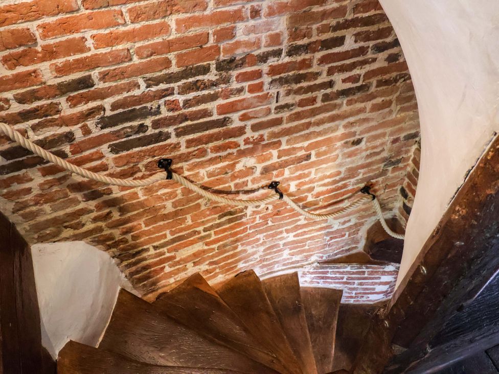 A staircase with wooden steps and a rope handrail at Keirs Cottage in Carlton Colville