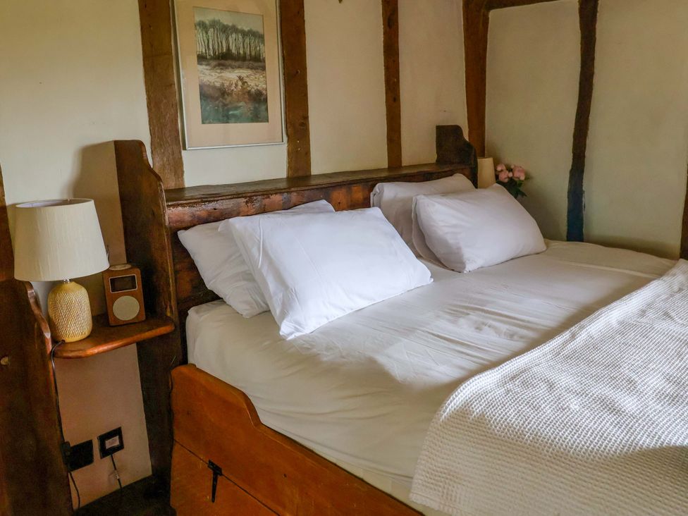 A bedroom with a bed and lamp at Keirs Cottage in Carlton Colville
